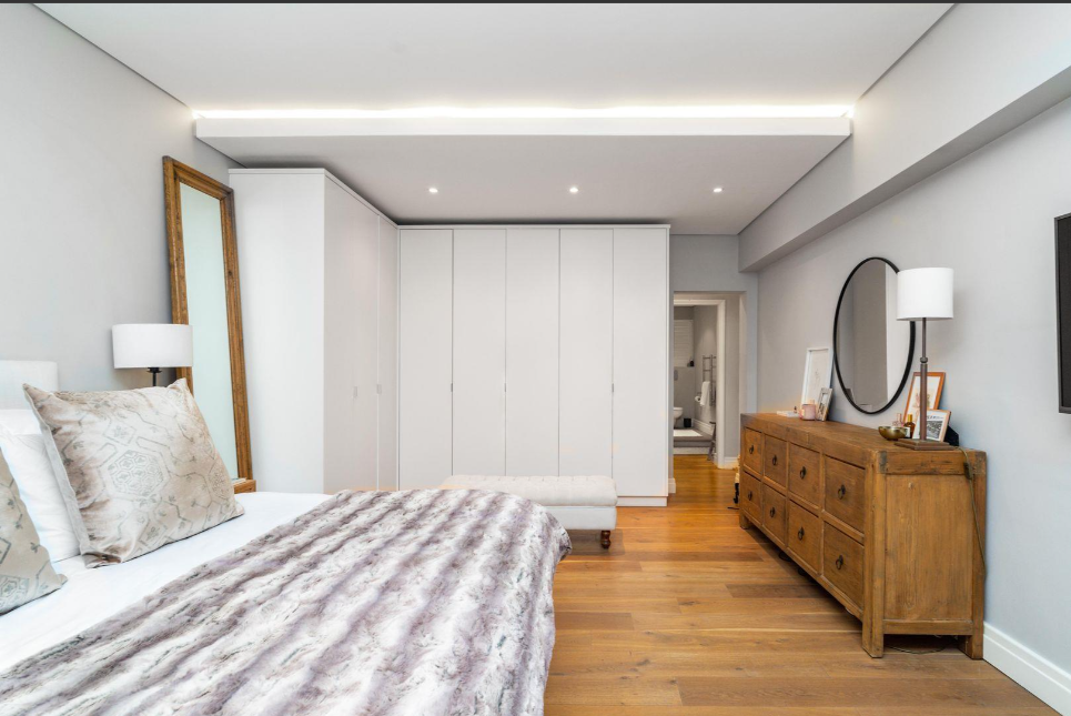 White hinged built-in wardrobes with timber accent doors in master bedroom, Durban