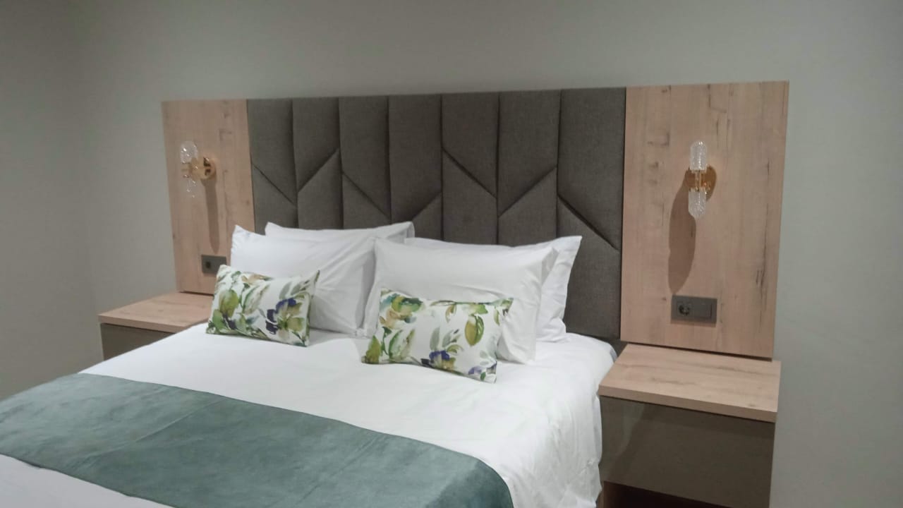 Contemporary headboard with LED lighting and matching bedside tables — Durban North by El-Shaddai Interiors