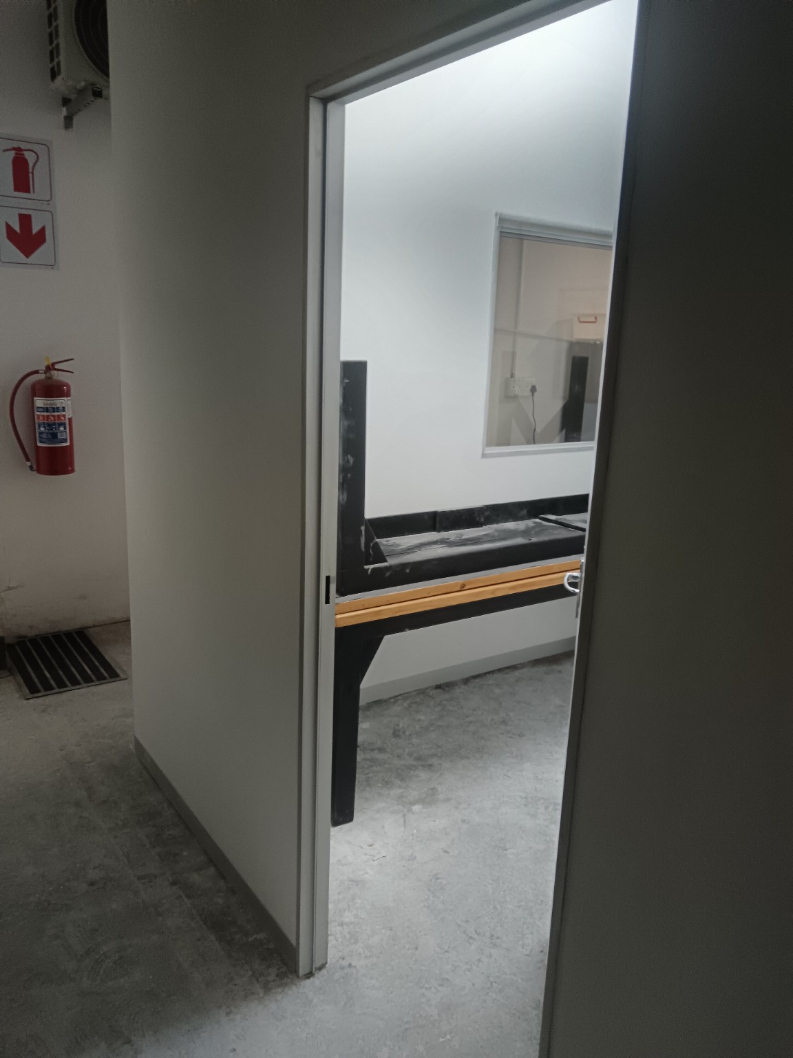 Door opening in a new drywall partition leading into a private office